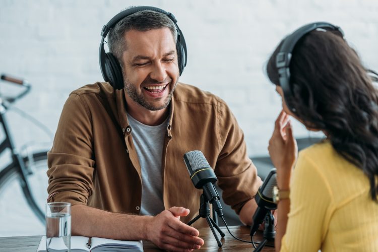 cheerful radio host laughing while recording podcast with colleague