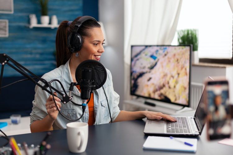 Woman in home studio recording podcast with mobile phone